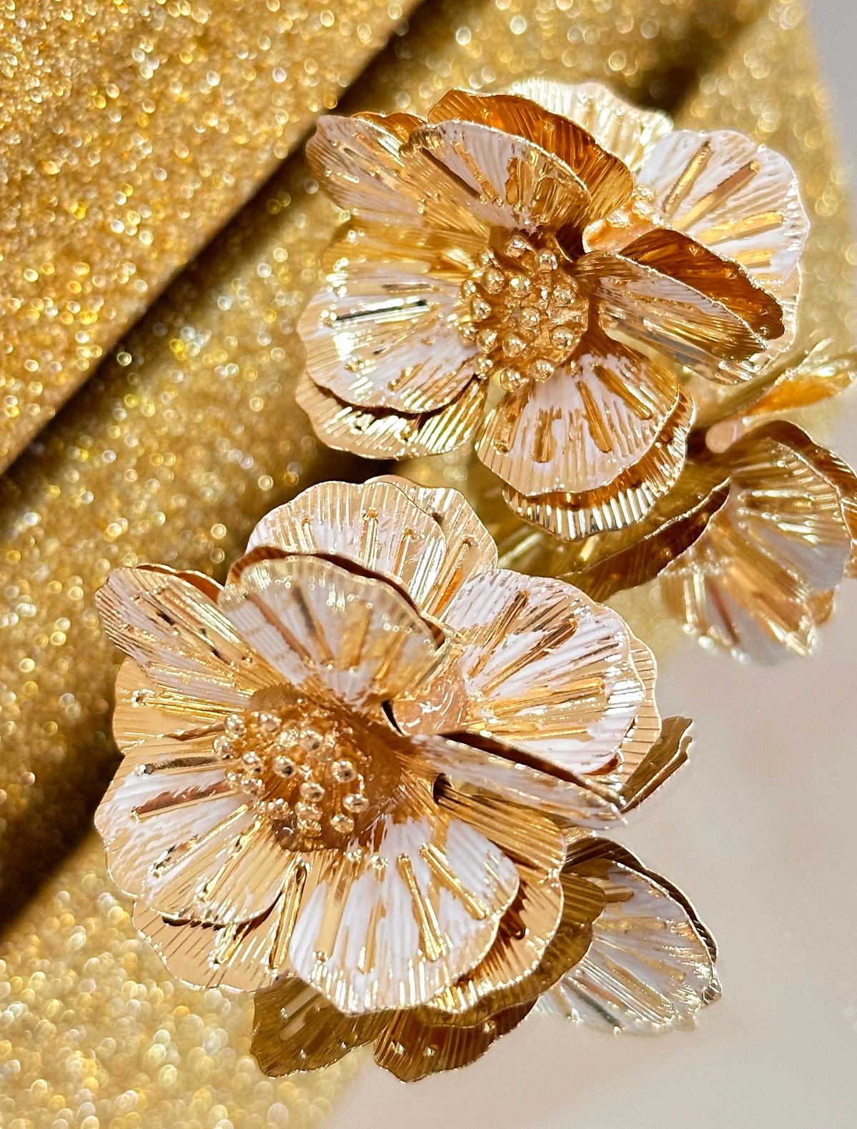 Brinco floral dourado texturizado com pétalas em relevo