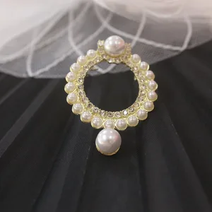 Broche dourado em formato de argola com pérolas