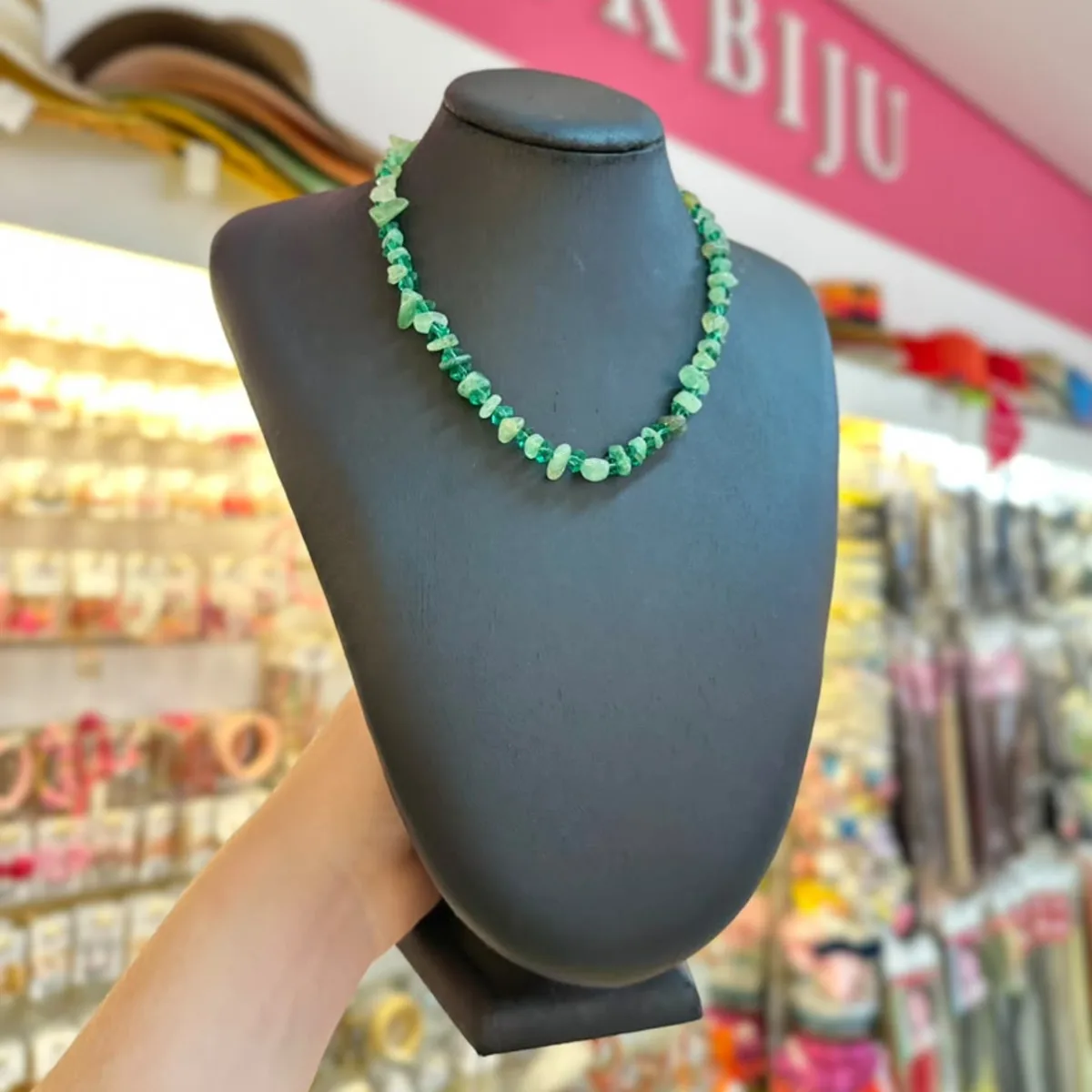 Colar de pedras verdes em fio curto, no busto preto da loja PinkBiju
