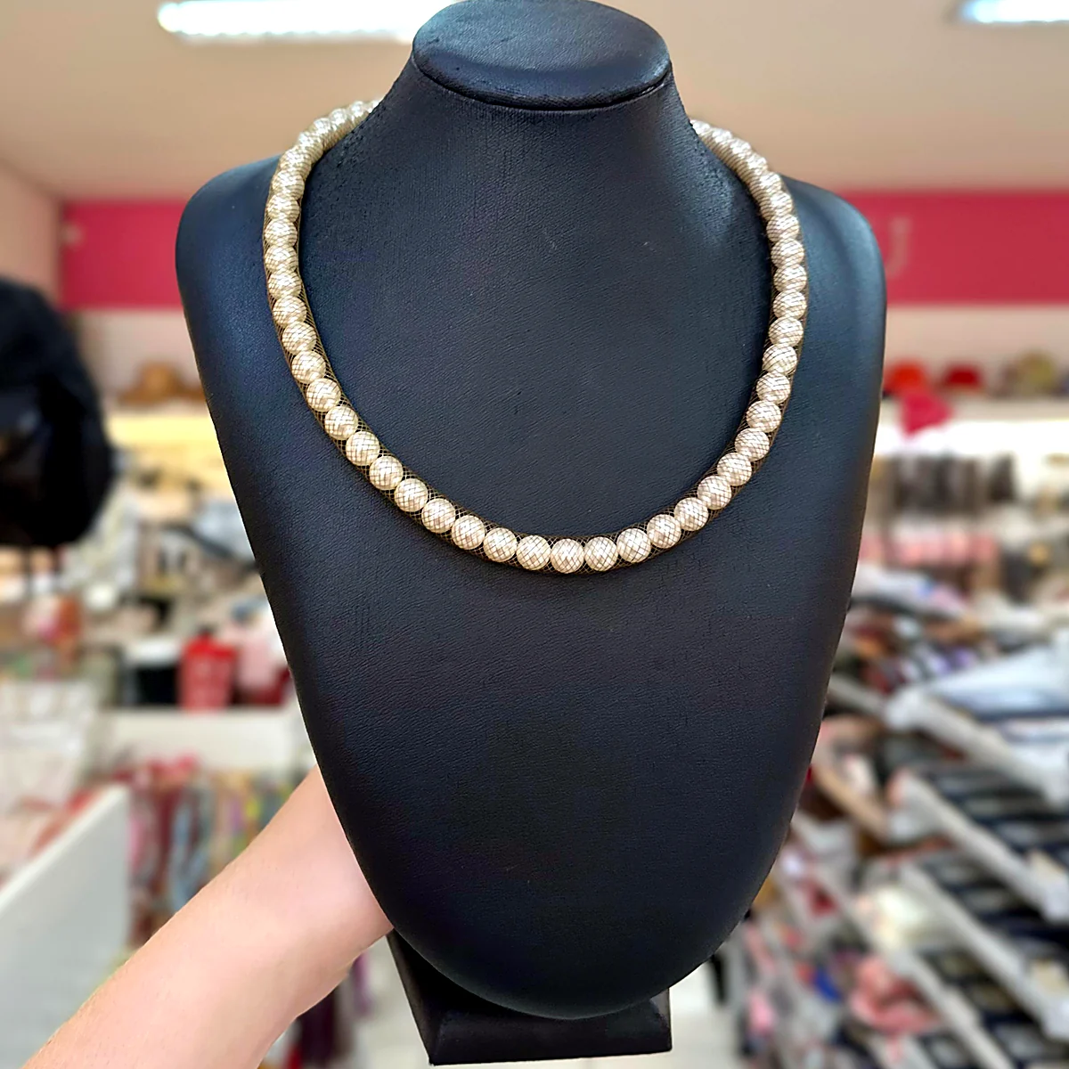 Colar de pérolas envoltas em tela fina dourada em busto preto na loja PinkBiju
