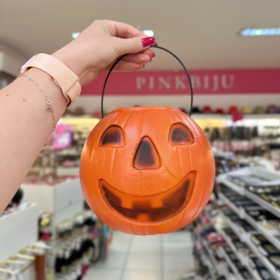 Balde de abóbora laranja com rosto sorridente para pegar doces no Halloween